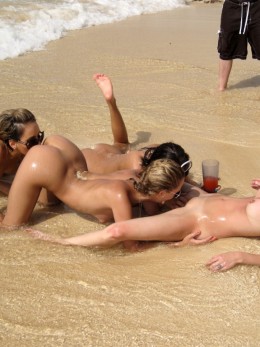 Голая девушка на пляже балуется и шалит