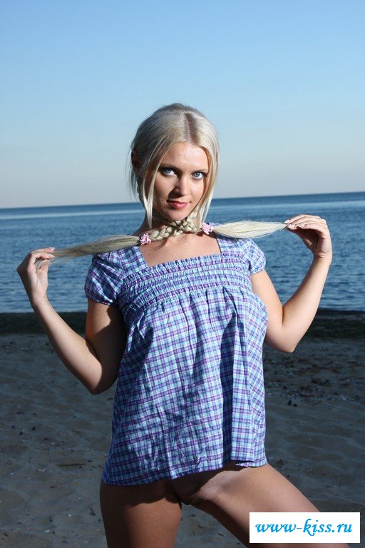 Симпатичная блондинка раздевается у моря