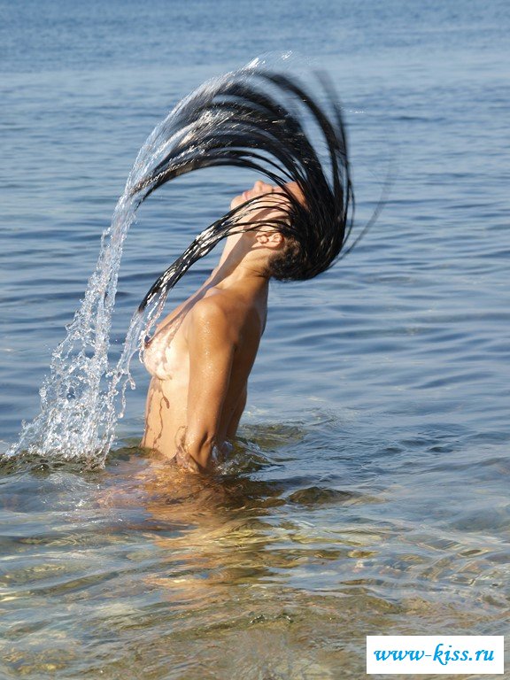 Привлекательная брюнетка раздевается в воде