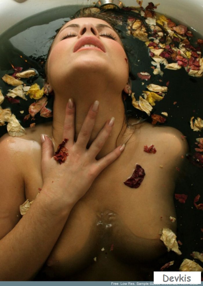 Красивая раздетая модель в ванной с цветами