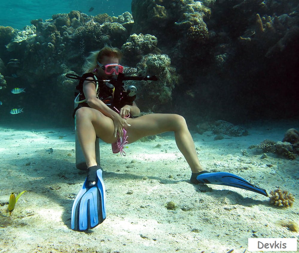 Голая аквалангистка ныряет под водой