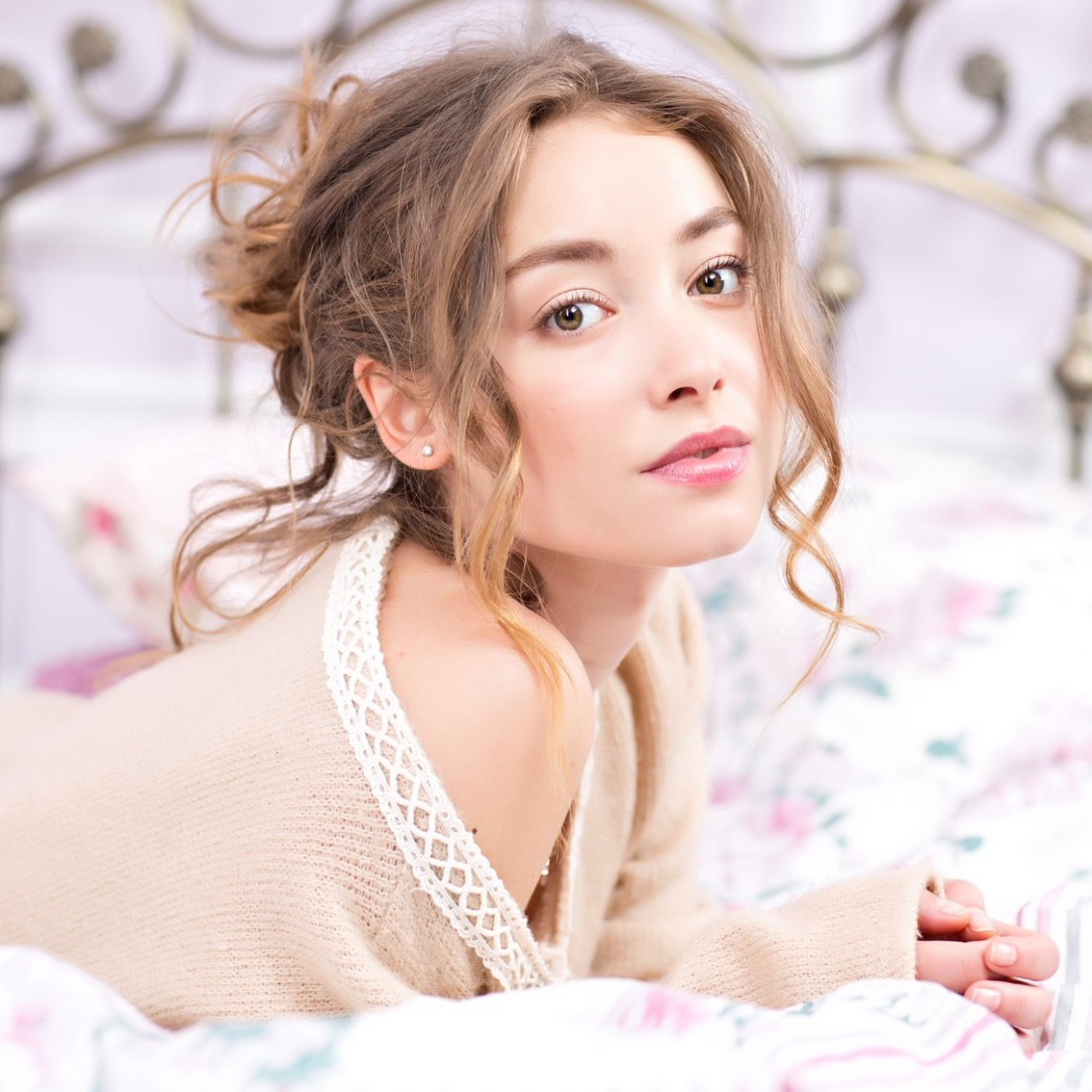 Девушка в кровати снимает лифчик