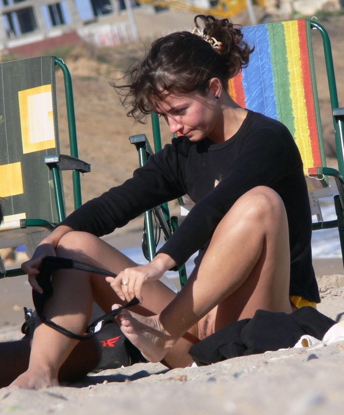 Переодевает трусики на пляже