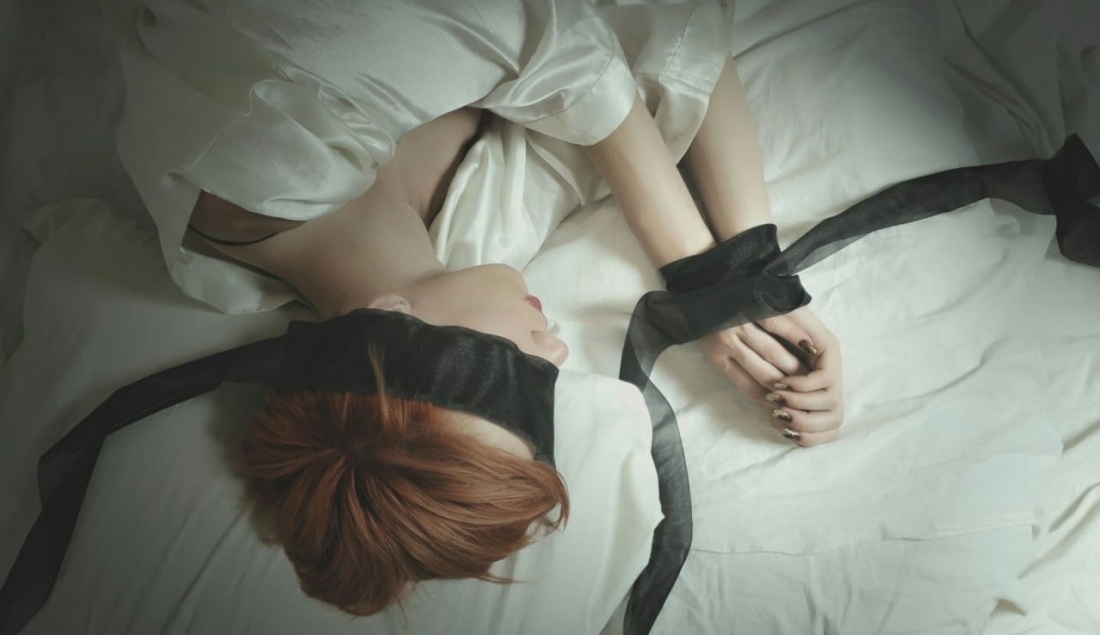 Связанная на кровати