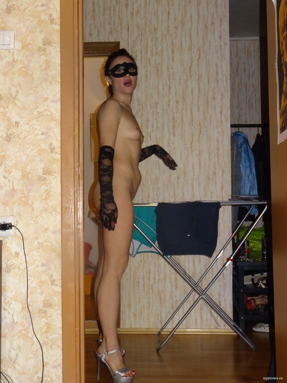 Жена в маске позирует частное ню