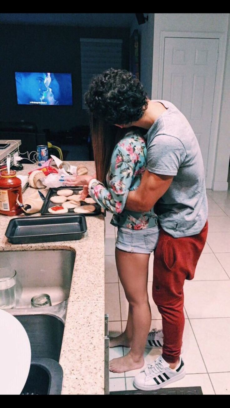 Парень обнимает на кухне