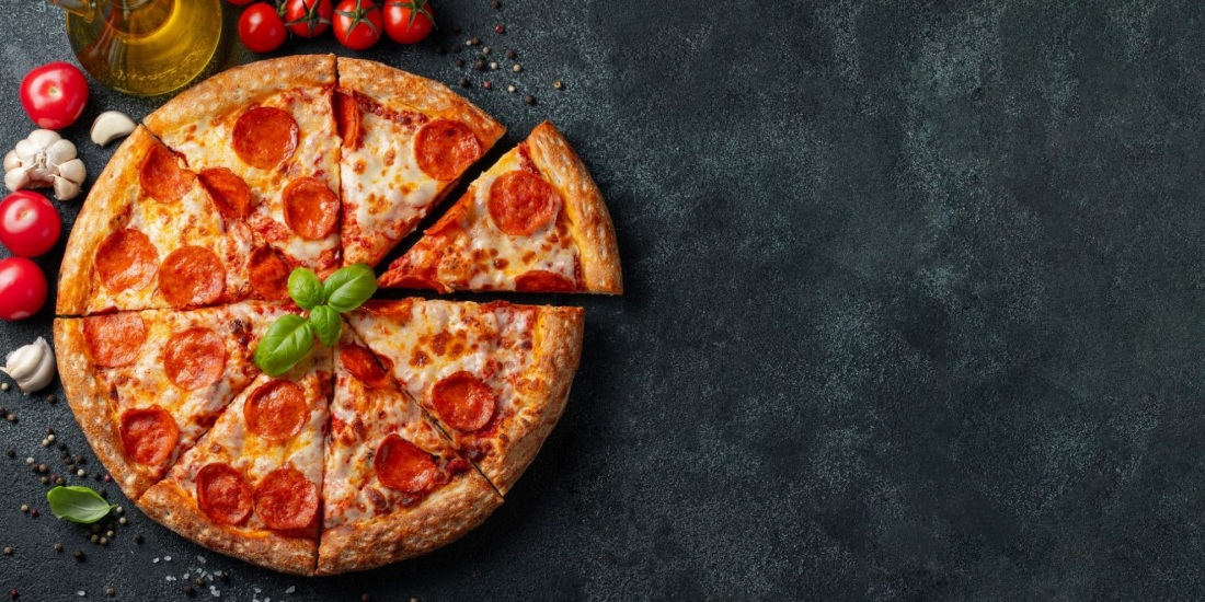 Пицца пепперони на черном фоне