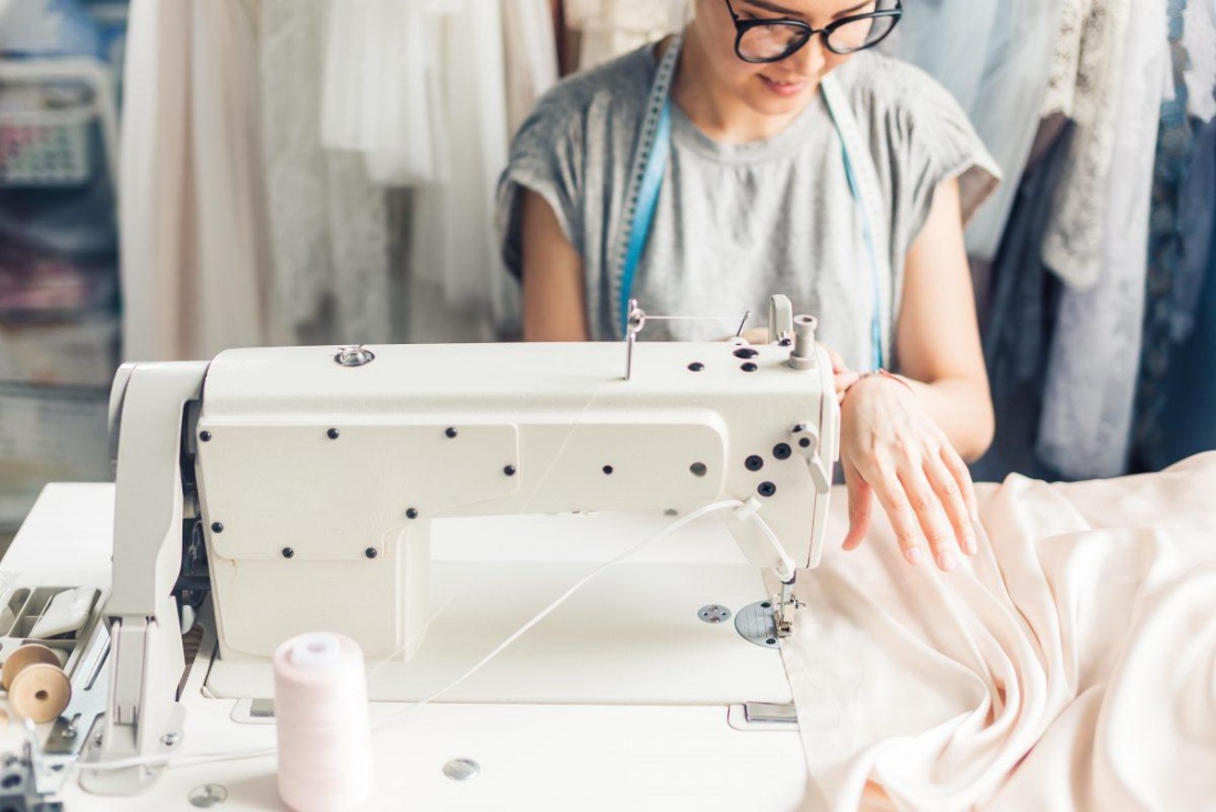 Швея шьет на швейной машинке
