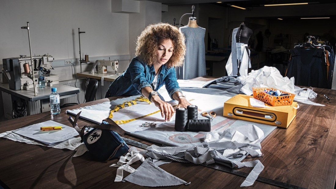 Девушка сидит за швейной машинкой