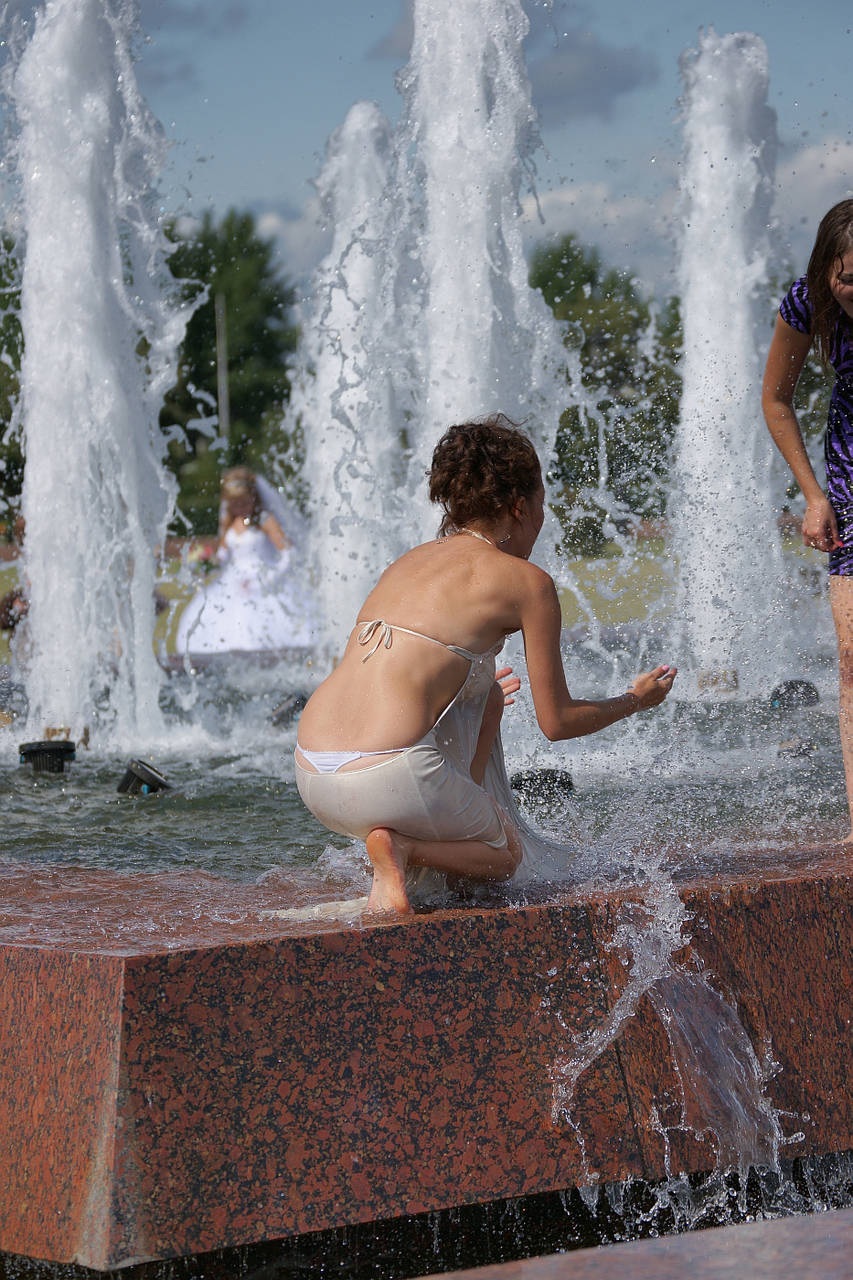 Мокрая девушка в фонтане