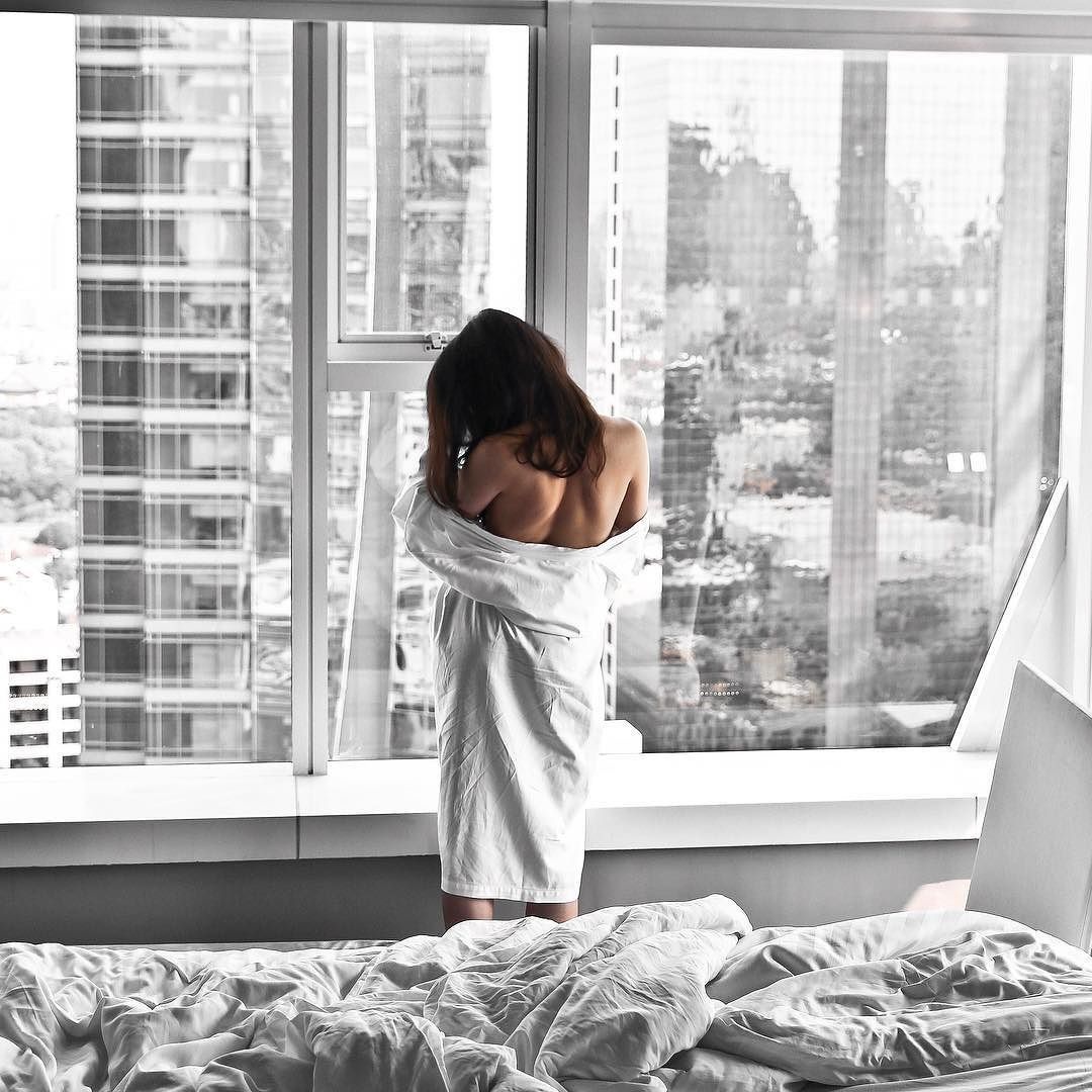 Девушка курит у окна