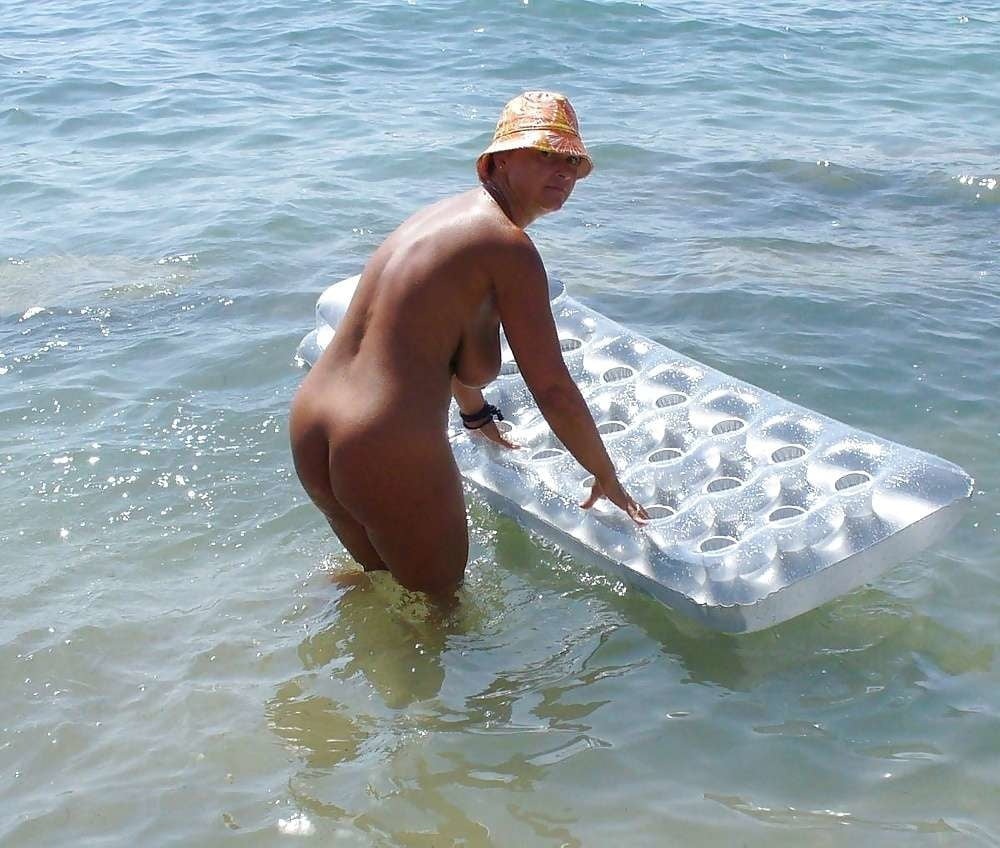 Зрелая плавает в море голышом