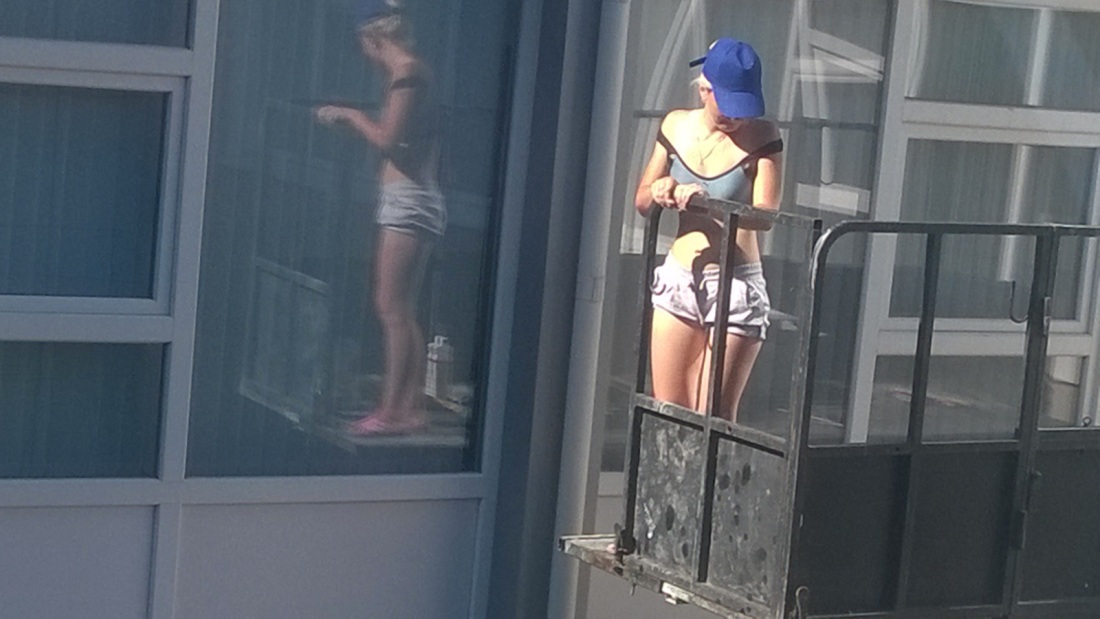 Девушка эротично моет окно