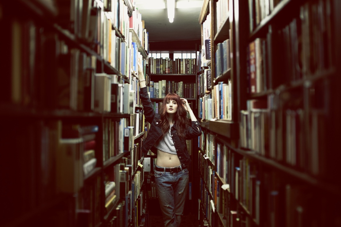 Девушка с книгой в библиотеке